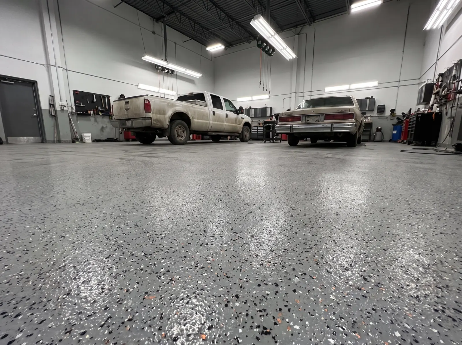 Atelier de réparation automobile avec plancher époxy à flocons industriels gris résistant aux huiles