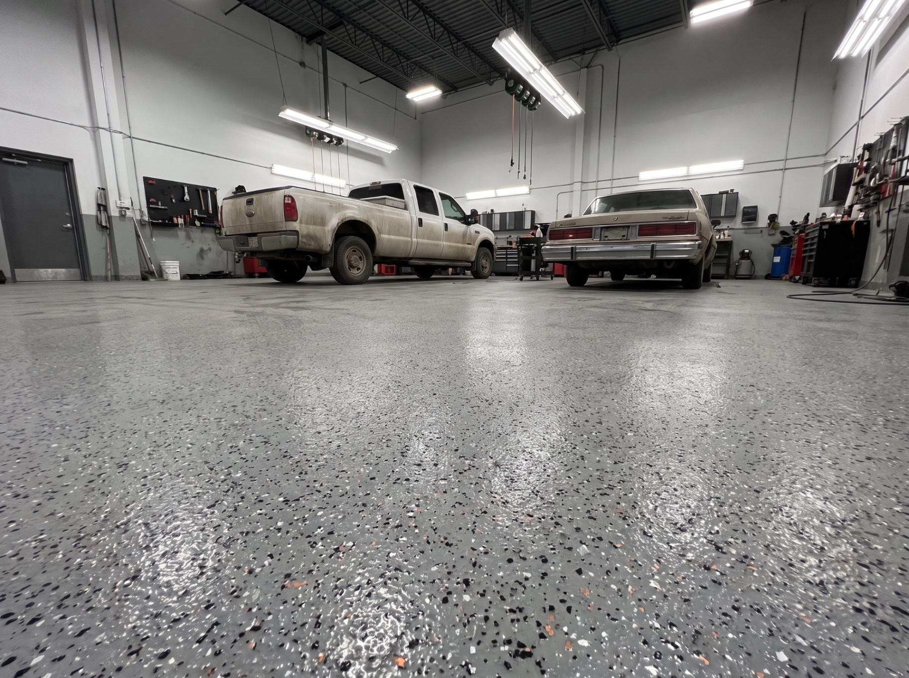 Atelier de réparation automobile avec plancher époxy à flocons industriels gris résistant aux huiles